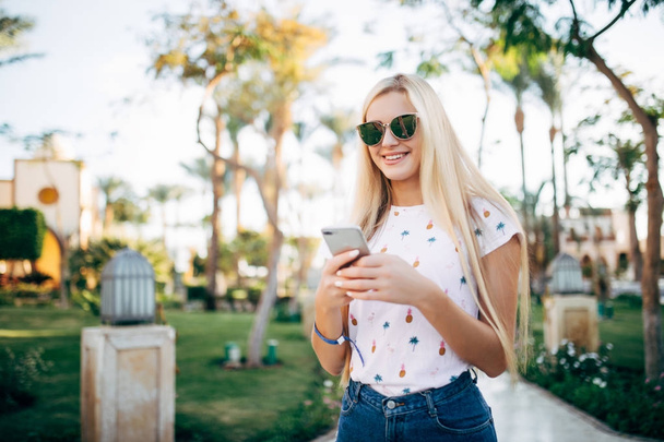 Donna turistica in vacanza con smart phone sulla spiaggia di palme ha bisogno di dati in roaming
 - Foto, immagini