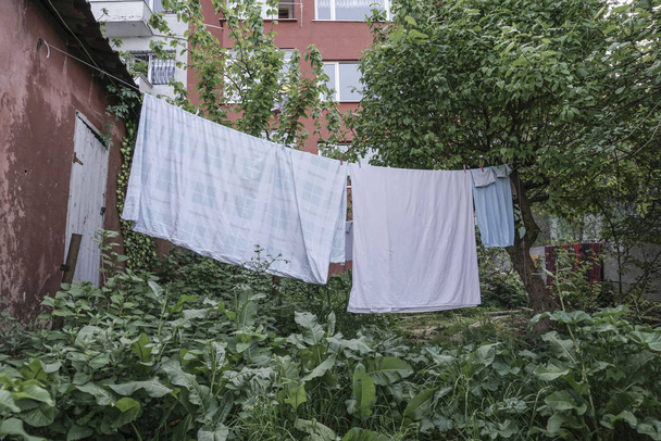 vestiti umidi appesi a giardino di un edificio
 - Foto, immagini