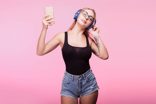 Sexy woman listening to music with a smartphone in hands - Foto, Imagem