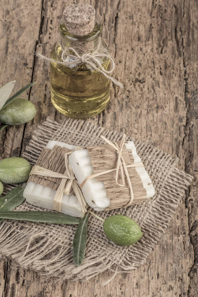 přírodní olivový olej mýdlo bary a láhev oleje na dřevěný stůl - Fotografie, Obrázek
