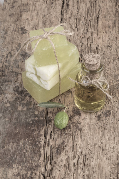 természetes olívaolaj szappan bárok és olaj üveg, fa tábla - Fotó, kép