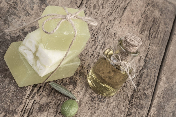 natural olive oil soap bars and oil bottle on wooden table - Foto, afbeelding
