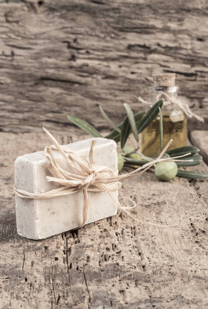 Natürliche Olivenölseife und Ölflasche auf Holztisch - Foto, Bild
