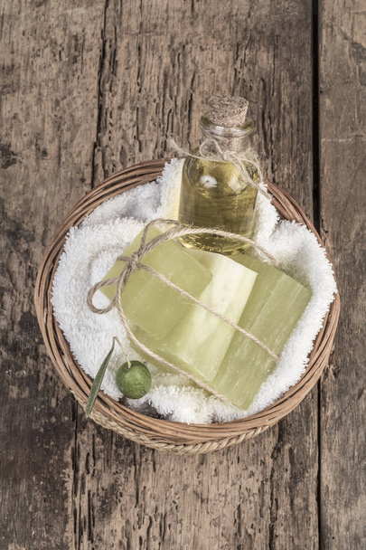 luonnollinen oliiviöljyn saippua baareja ja oliiviöljyn pullo korissa
 - Valokuva, kuva