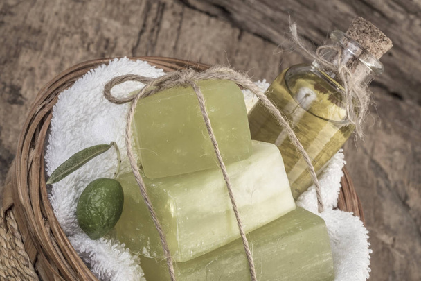 natuurlijke olijfolie zeep bars en olijfolie fles in een mandje - Foto, afbeelding
