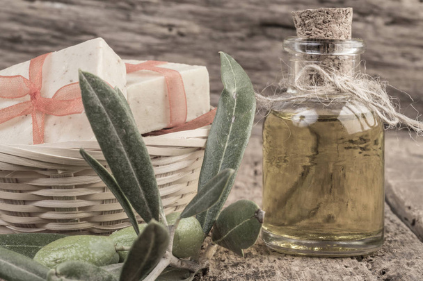 natuurlijke olijfolie zeep bars en olijfolie fles op houten tafel - Foto, afbeelding