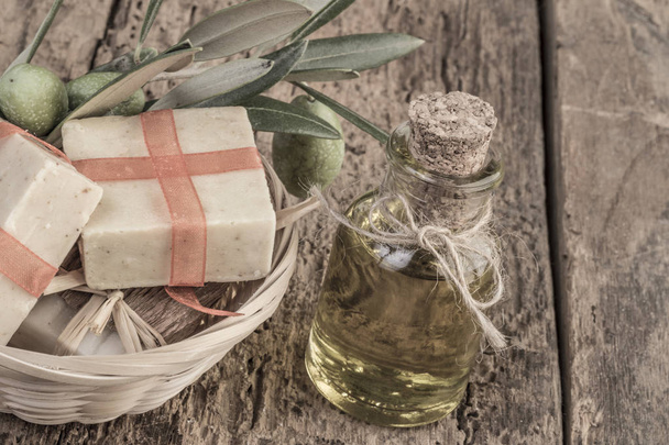 Doğal zeytinyağı sabun Bar ve zeytinyağı şişesi üzerinde ahşap masa - Fotoğraf, Görsel