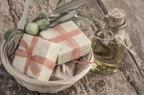 натуральні оливкові мильні батончики та пляшка оливкової олії на дерев'яному столі
 - Фото, зображення