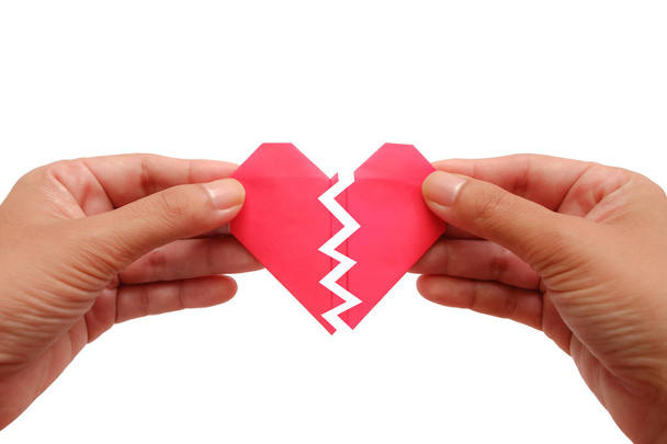 Hand met rode papier gebroken hart op een witte achtergrond voor unloveable op Valentijnsdag concept - Foto, afbeelding