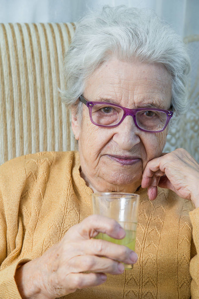 старша жінка тримає стакан лимонаду
 - Фото, зображення