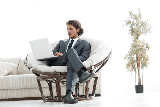 modern businessman with a laptop sitting in a stylish comfortable chair - Zdjęcie, obraz