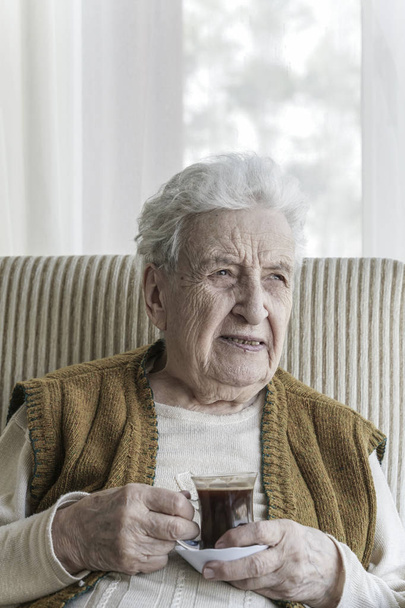 Старшая женщина пьет кофе - Фото, изображение