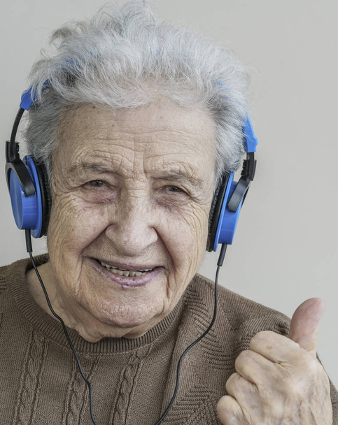 Счастливая пожилая женщина слушает музыку в наушниках
 - Фото, изображение