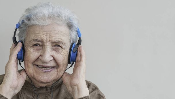 senior woman listening music with headphones - Photo, Image