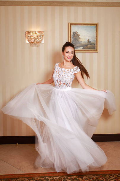 Beautiful wedding dress. Bride in wedding dress in a luxury apartment. - Фото, зображення