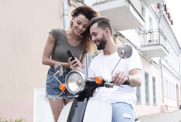 Young happy couple riding scooter together  smiling - Фото, изображение