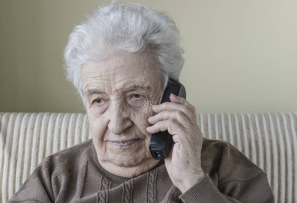 Thoughtful senior woman on phone - 写真・画像