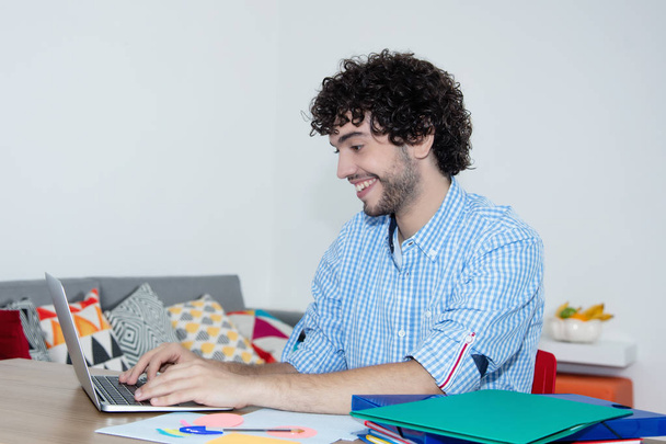 Laughing caucasian hipster working at home with computer - Foto, Bild