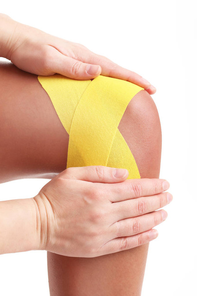 Picture showing special physio tape put on injured knee over white background - Fotoğraf, Görsel