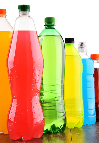 Plastikowe butelki różnych gazowanych napojów bezalkoholowych na białym tle - Zdjęcie, obraz
