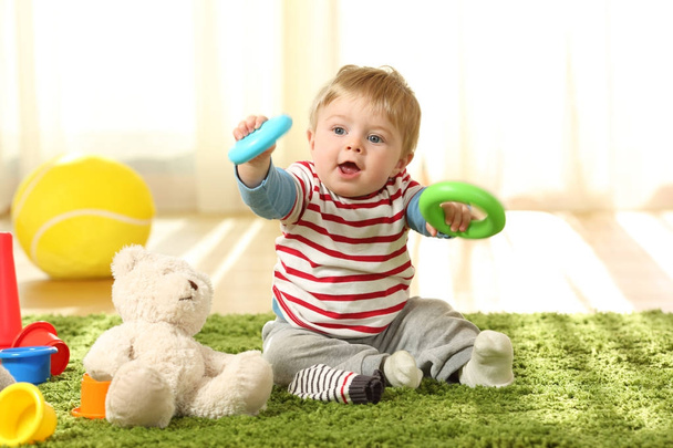 Baby playing with toys on a carpet - Фото, изображение