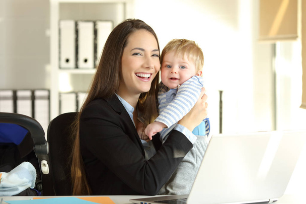 Happy working mother posing with her baby at office - Photo, Image