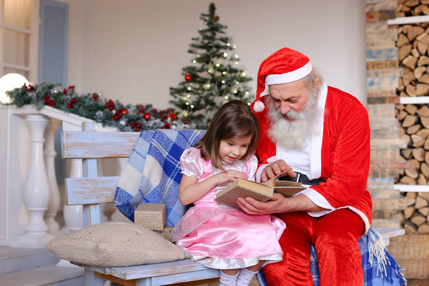 Dziadek, grając rolę Świętego Mikołaja dla wnuczka. - Zdjęcie, obraz