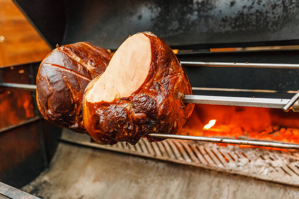 a grilled pork knee on a fire - 写真・画像
