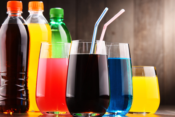 Glasses and bottles of assorted carbonated soft drinks in variety of colors - Photo, Image