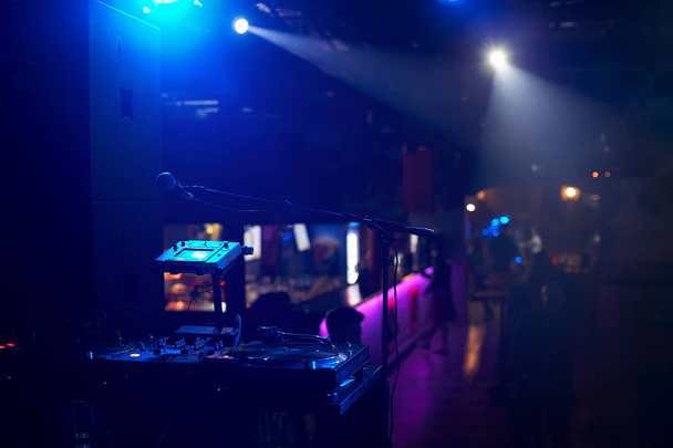 Closeup of a remote DJ with vinyl discs in a nightclub with a be - Photo, Image