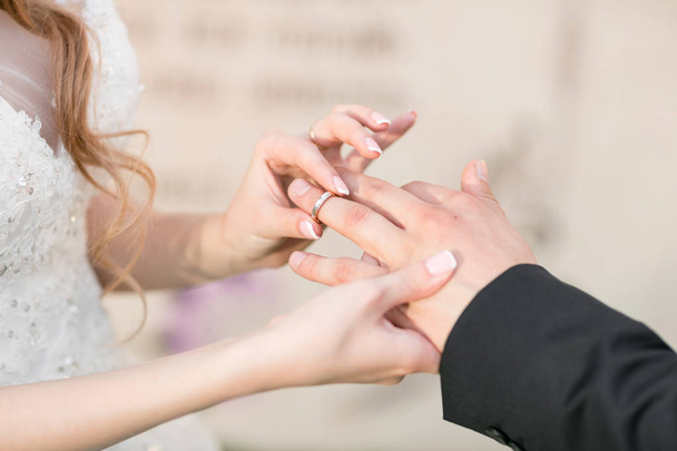 Trauringe und Hände von Braut und Bräutigam. junges Hochzeitspaar bei der Zeremonie. Ehe. Mann und Frau verliebt. zwei glückliche Menschen feiern Familienzuwachs - Foto, Bild