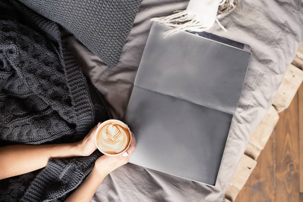上から見る朝ベッド ウール毛布や雑誌のページの空スペースでコーヒー - 写真・画像