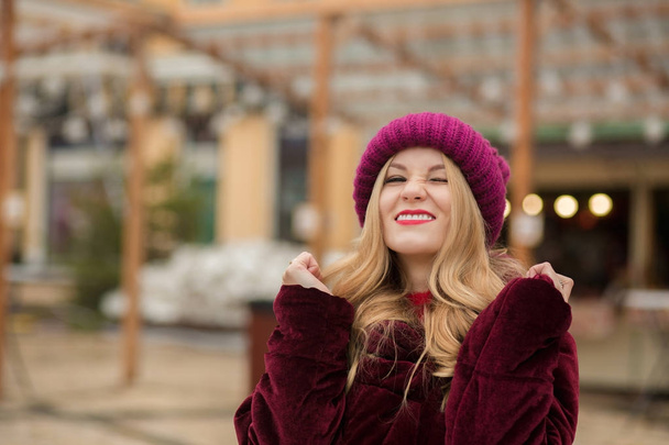 Divertente giovane modella con cappello a maglia rossa e cappotto invernale, posin
 - Foto, immagini