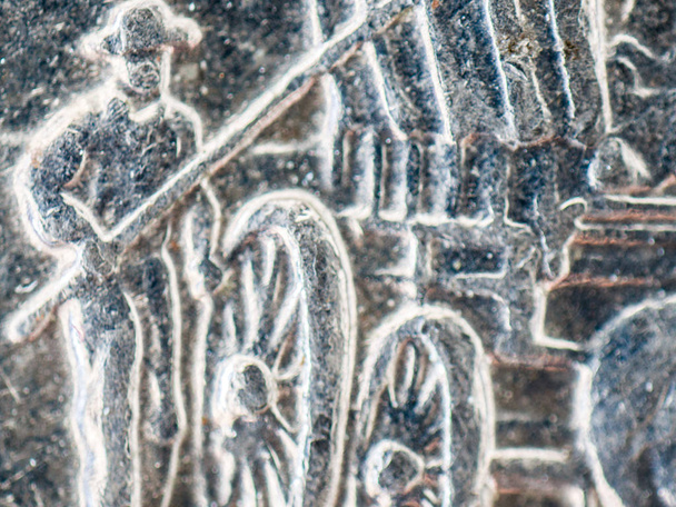 Um detalhe macro de close-up extremo imagem microscópica de um homem que está ao lado de um vagão coberto em uma moeda de quarto de dólar de prata dos EUA, incluindo imperfeições e manchas
. - Foto, Imagem