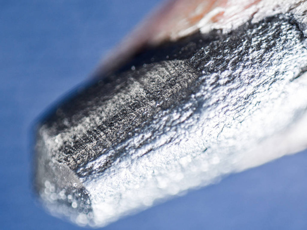 Un'immagine microscopica della punta di una matita in legno grigio grafite con texture e imperfezioni complesse
. - Foto, immagini