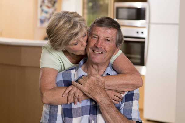 krásné, středního věku pár kolem 70 let, usmíval se šťastný spolu doma kuchyň vypadající sladká žena manžela líbat sladce  - Fotografie, Obrázek