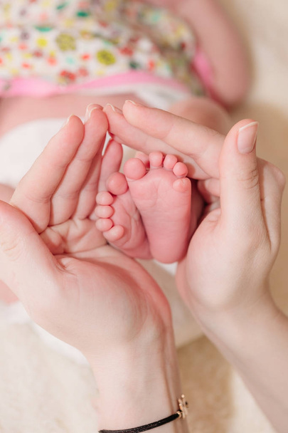 Anya a babys láb tartja a tenyerét a kezét - Fotó, kép