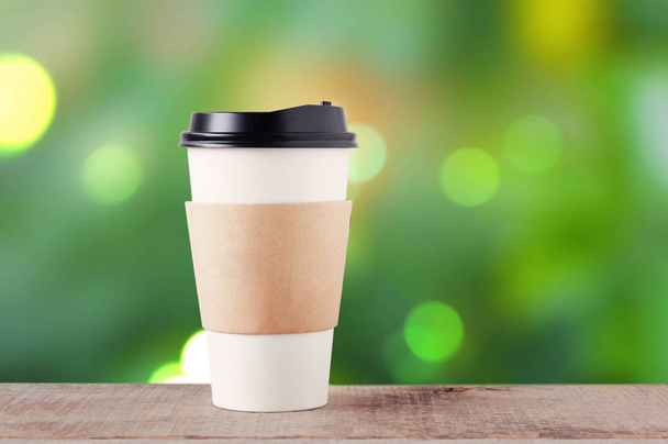 Кофейная чашка бумаги на зеленом фоне
. - Фото, изображение