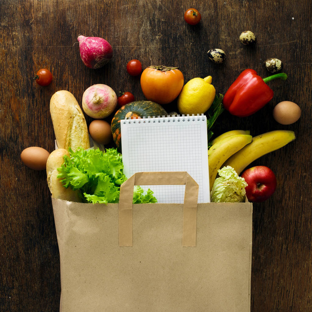 Paper bag different health food notebook wooden background Top v - Foto, Imagem