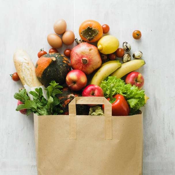 Paper bag of different health food on white wooden background - Foto, Imagem