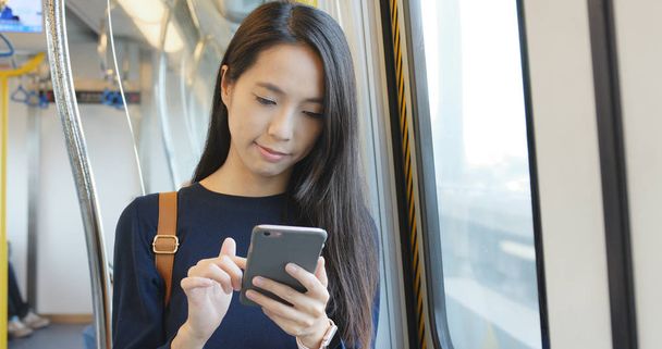 Γυναίκα με τη χρήση smartphone στο εσωτερικό της θήκης τρένο - Φωτογραφία, εικόνα