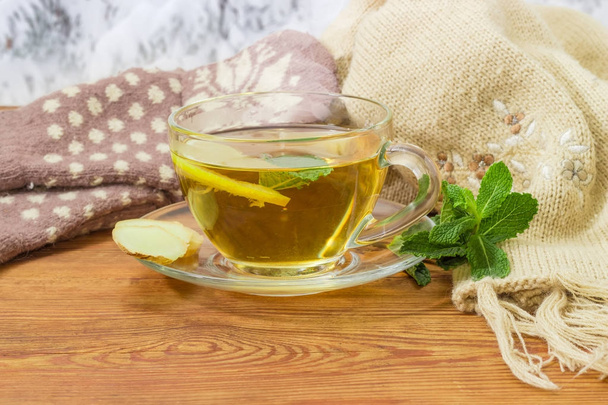 Чай с лимоном, мятой, имбирем и шерстяными варежками, шарф на открытом воздухе
 - Фото, изображение