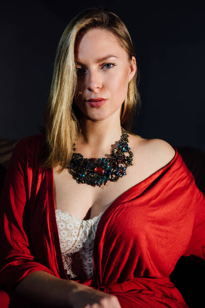 Beautiful sexy lady in elegant red robe. Fashion portrait of model indoors. - Φωτογραφία, εικόνα