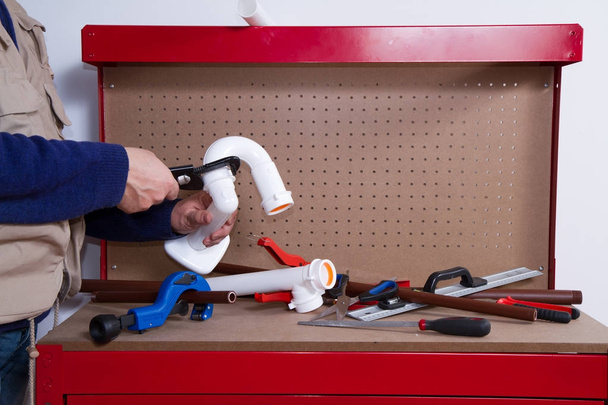 plumber at work on his workbench to fit pipes - Photo, image