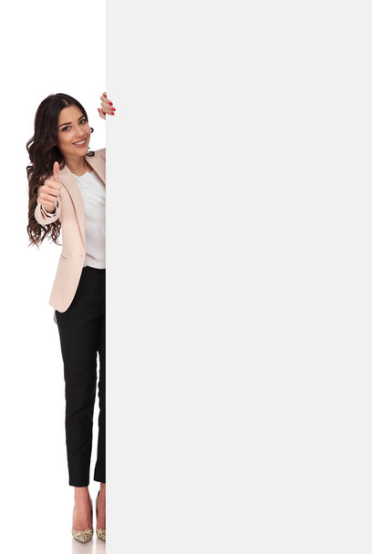 junge Geschäftsfrau präsentiert große weiße Plakatwand und macht ok  - Foto, Bild