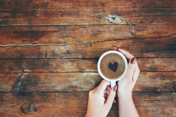 eine Tasse Kaffee in den Händen einer Frau. Selektiver Fokus. - Foto, Bild