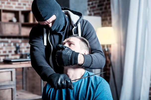 Scared man and killer holding knife on his neck - Φωτογραφία, εικόνα