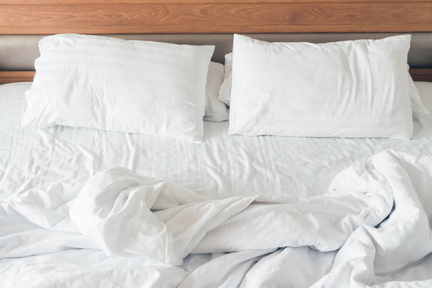 Белая подушка со смятой отделкой кровати в интерьере спальни
 - Фото, изображение