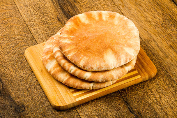 Pita kenyér halom felett a fából készült háttér - Fotó, kép