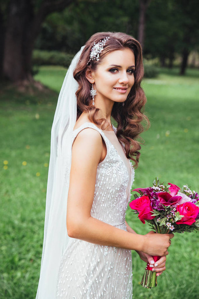 Beautiful bride outdoors in a park . Bridal style - 写真・画像